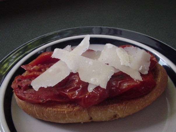 slow oven-roasted herbed tomatoes on a roll with parmesan shavings